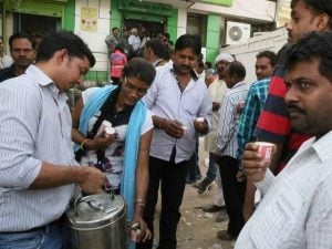 tea-seller-selling-tea-to-people-standing-in-the-queue-outside-an-atm